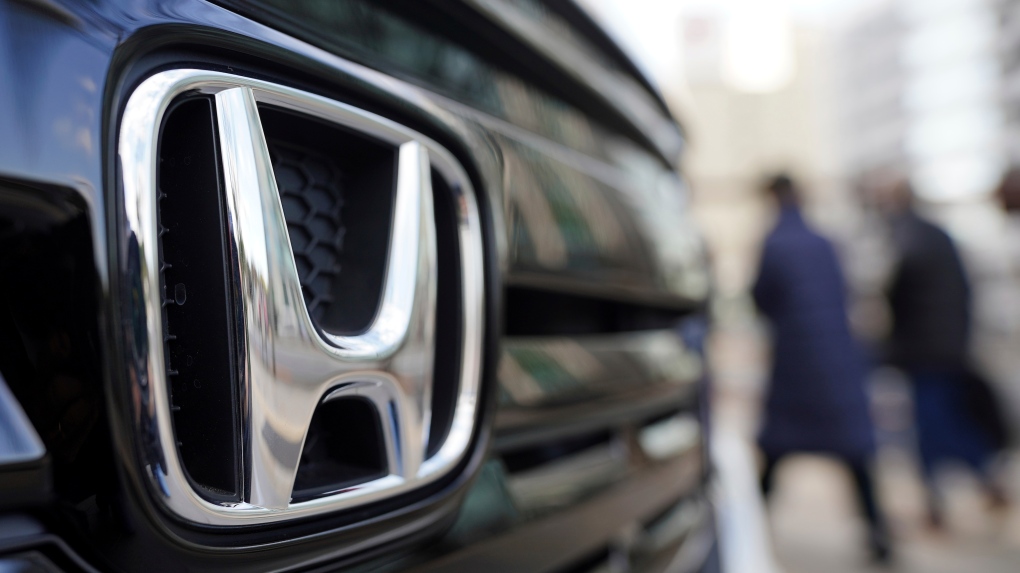 People walk near the logo of Honda Motor Company at a showroom Tuesday, Feb. 8, 2022, in Tokyo. (AP Photo/Eugene Hoshiko, File)