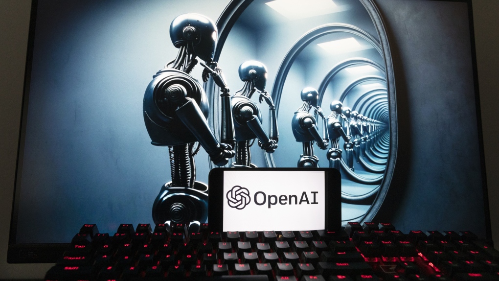 The OpenAI logo is seen displayed on a cell phone with an image on a computer screen generated by ChatGPT's Dall-E text-to-image model, Friday, Dec. 8, 2023, in Boston. (AP Photo/Michael Dwyer)